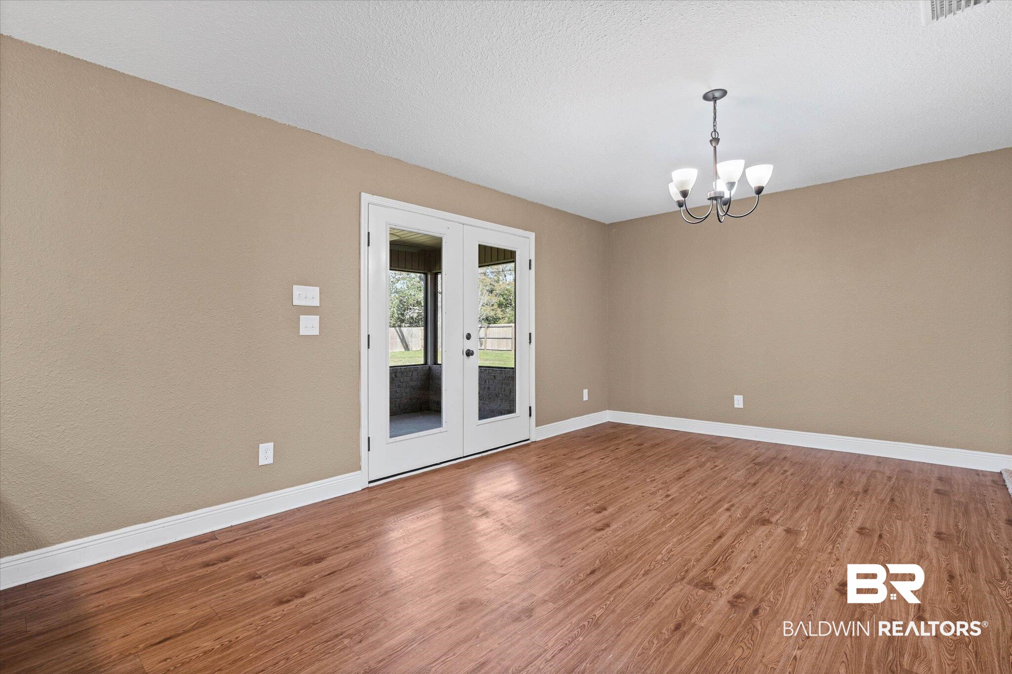 101 Washington Boulevard Foley, AL 36535 - Photo 8 of 32 Unfurnished room with french doors, light wood-style floors, a chandelier, and a textured ceiling