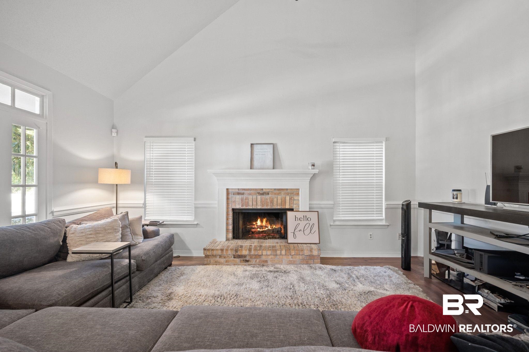 6705 Autumn Ridge Drive Mobile, AL 36695 - Photo 9 of 24 Living room featuring a brick fireplace, high vaulted ceiling, and hardwood / wood-style flooring