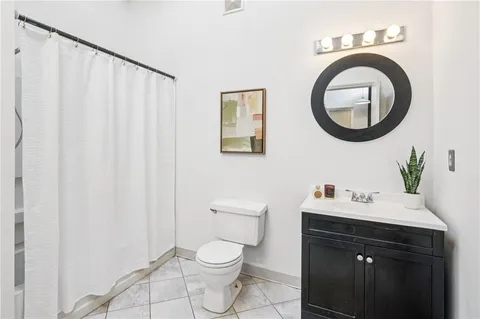 a bathroom with a sink a toilet and a mirror