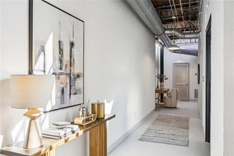 a view of a hallway with wooden floor and a living room