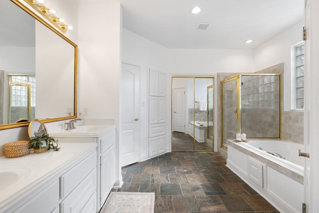 1815 Rue De St Tropez Austin, TX 78746 - Photo 15 of 39 Bathroom featuring double vanity, a stall shower, a garden tub, dark stone finish flooring, and recessed lighting