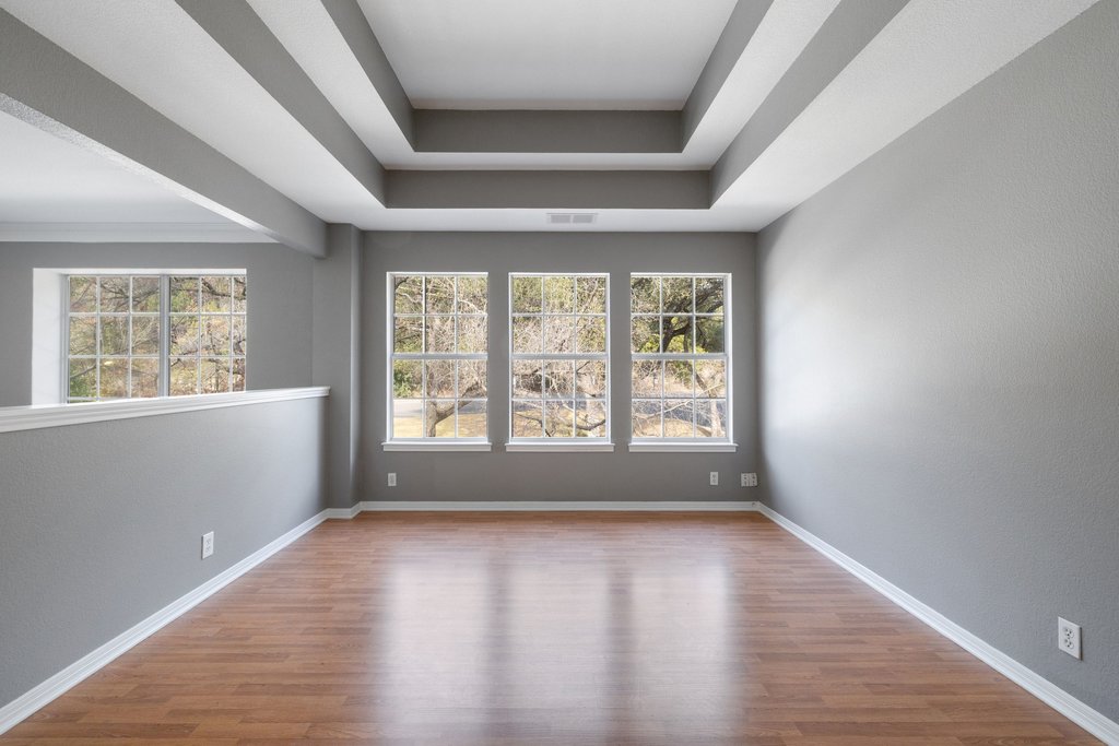 1815 Rue De St Tropez Austin, TX 78746 - Photo 20 of 39 Empty room featuring light wood-style flooring and a tray ceiling