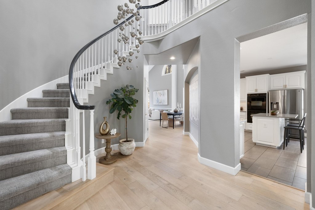 1815 Rue De St Tropez Austin, TX 78746 - Photo 8 of 39 Stairway with a high ceiling, hardwood / wood-style floors, and arched walkways