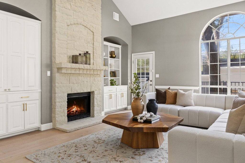 1815 Rue De St Tropez Austin, TX 78746 - Photo 9 of 39 Living area with vaulted ceiling, light wood-style floors, built in shelves, and a fireplace