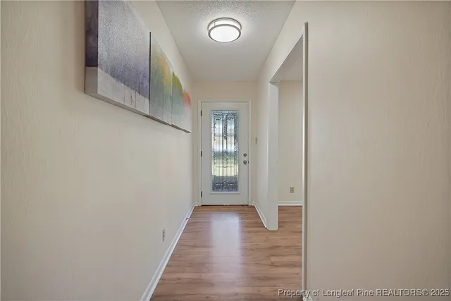 a view of a hallway with wooden floor