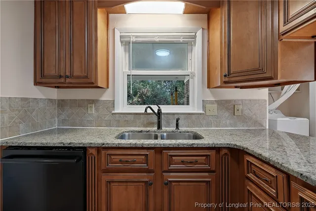 a kitchen with granite countertop a sink stainless steel appliances and cabinets