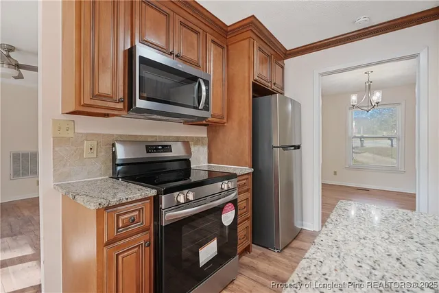 a kitchen with stainless steel appliances granite countertop a refrigerator stove and microwave