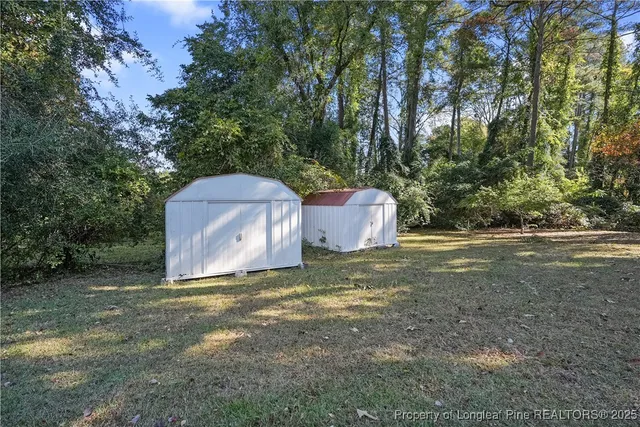 a backyard of a house with trees and outdoor seating