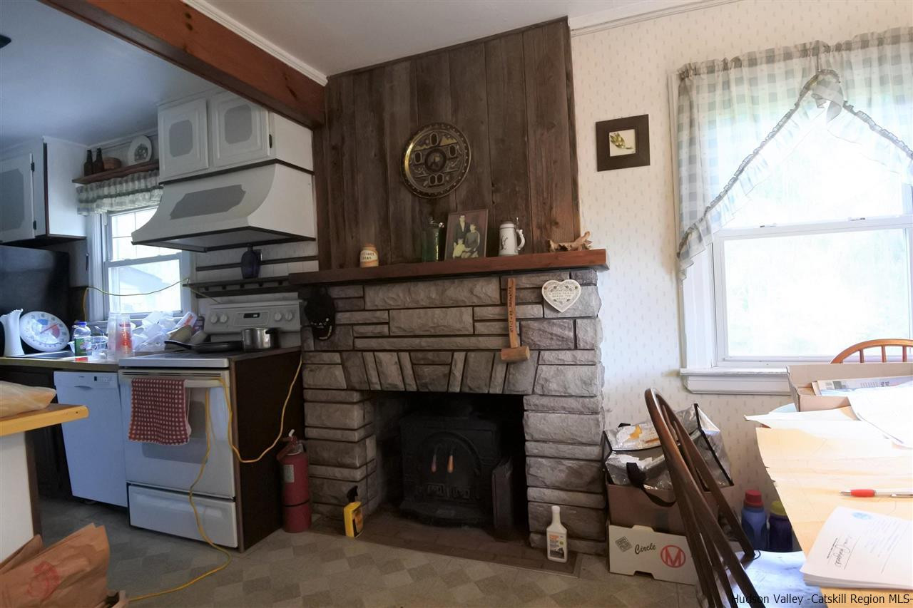 284 Bush Road Stone Ridge, NY 12484 - Photo 11 of 34 a kitchen with a stove and a fireplace
