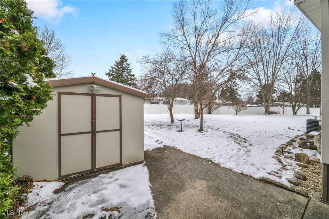 27202 Cook Road, Unit 95 Olmsted Falls, OH 44138 - Photo 35 of 46 Snowy yard featuring a storage unit and a fenced backyard