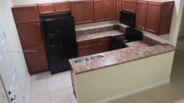 a kitchen with granite countertop a refrigerator and a stove