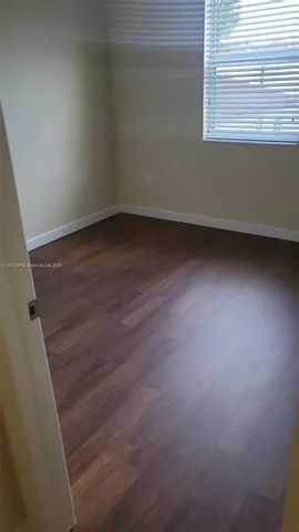 a view of a small space with wooden floor and a window