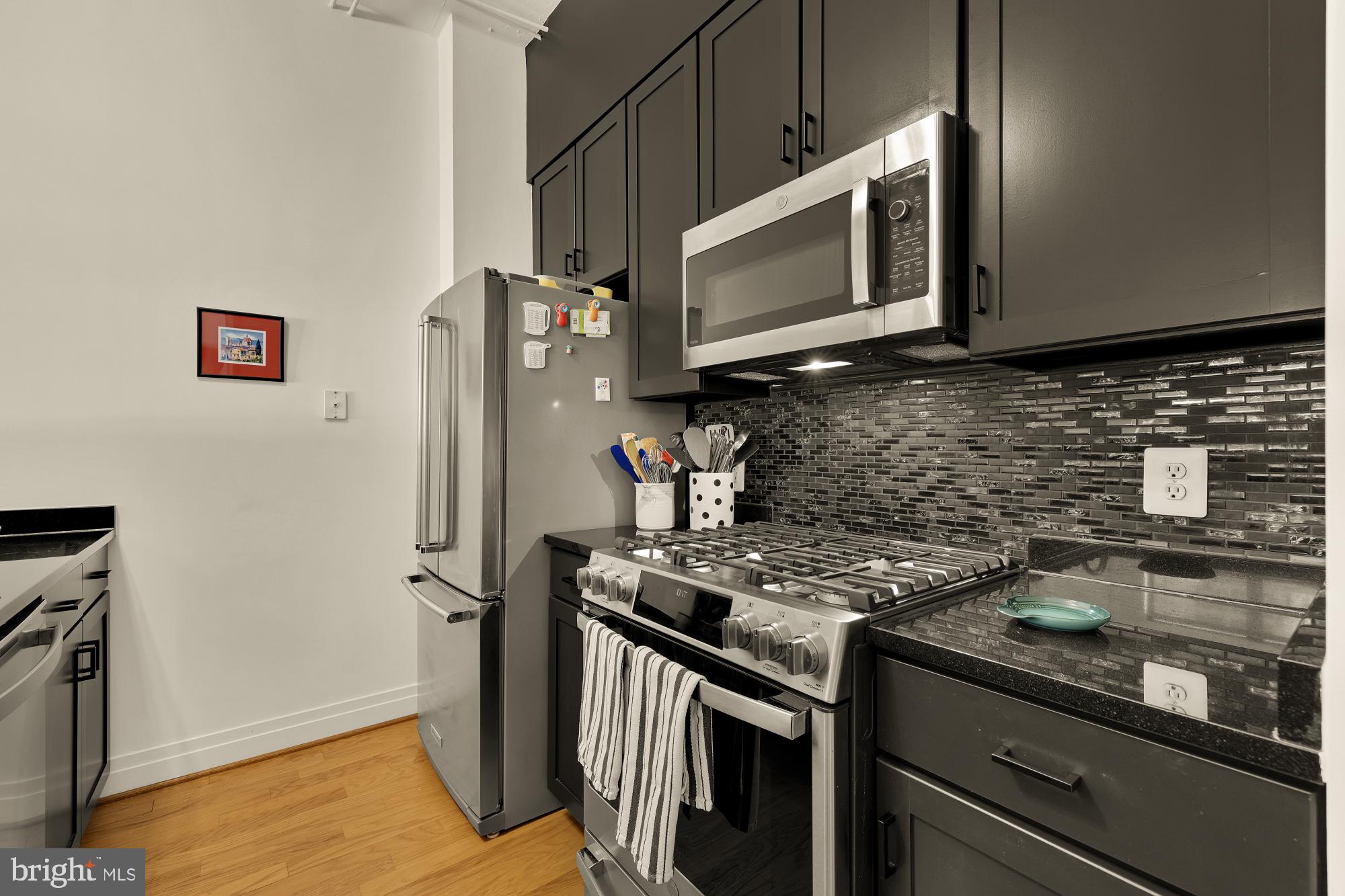 2020 12th Street Northwest, Unit 518 Washington, DC 20009 - Photo 6 of 28 a kitchen with stainless steel appliances granite countertop a stove microwave and refrigerator