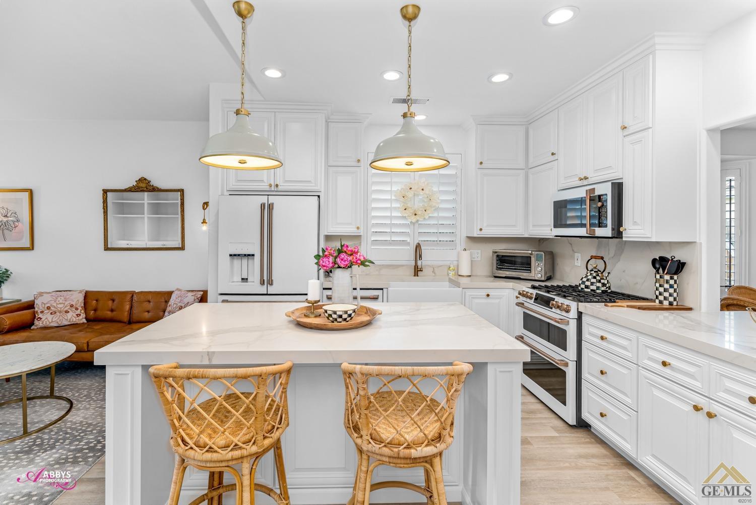 Undisclosed Address Bakersfield, CA 93311 - Photo 13 of 48 a kitchen with stainless steel appliances kitchen island granite countertop a stove a sink a dining table and chairs with wooden floor