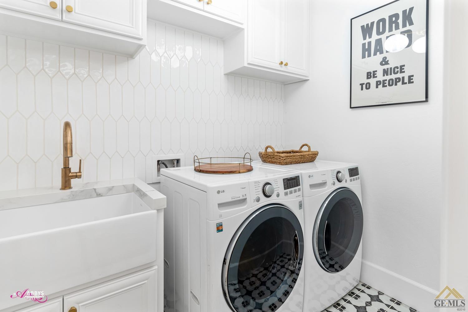 Undisclosed Address Bakersfield, CA 93311 - Photo 27 of 48 Laundry room has upper cabinets, utility sink, tile backsplash and tile flooring.