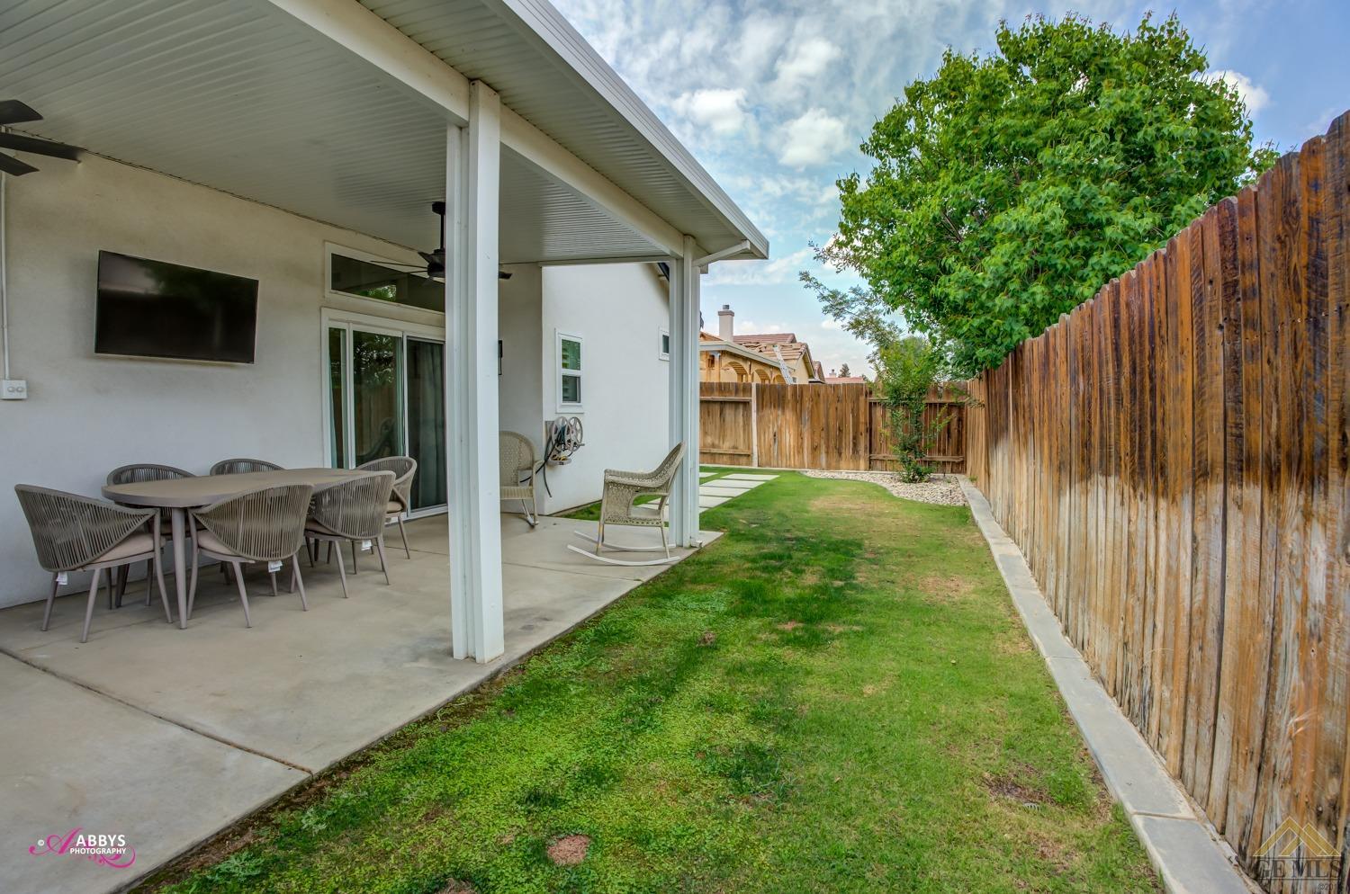 Undisclosed Address Bakersfield, CA 93311 - Photo 34 of 48 a view of a backyard with table and chairs and potted plants