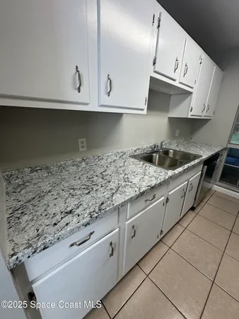 a kitchen with granite countertop white cabinets and a stove