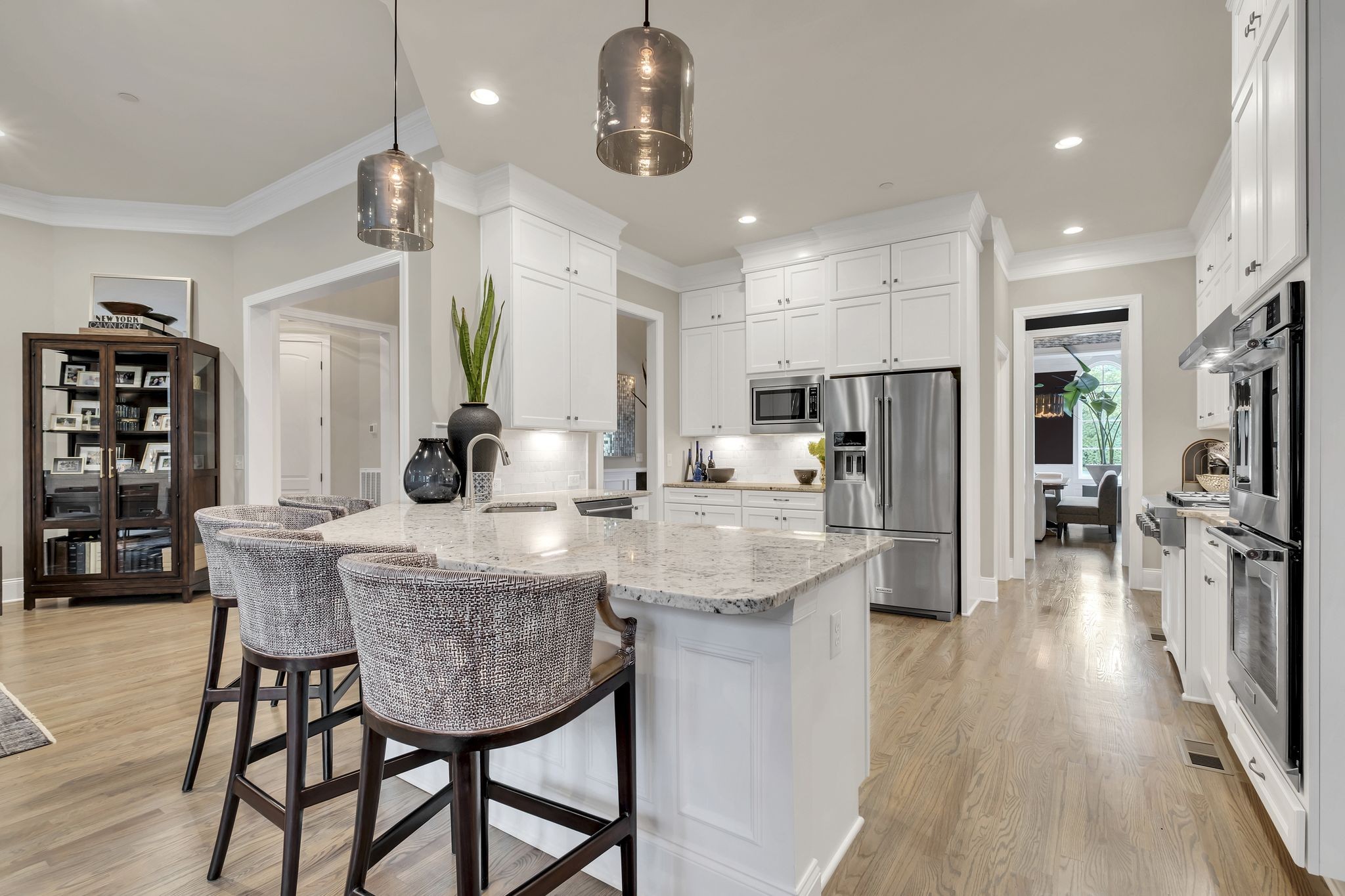1043 Firestone Drive Franklin, TN 37067 - Photo 16 of 61 a kitchen with stainless steel appliances kitchen island granite countertop a table chairs refrigerator and microwave