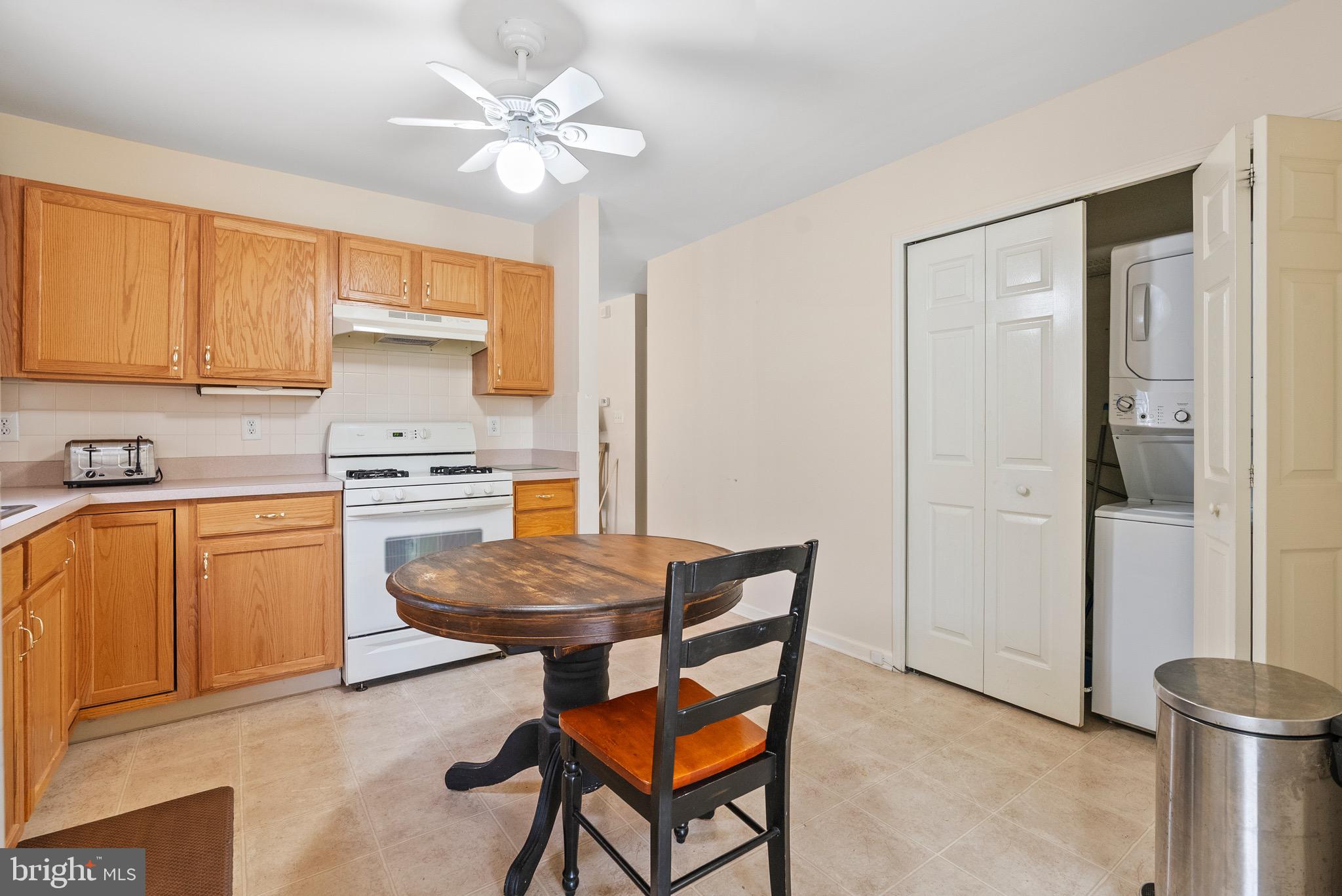 26 Carriage Berlin, NJ 08009 - Photo 8 of 19 a kitchen with a refrigerator a stove a sink dishwasher and a dining table with wooden cabinet