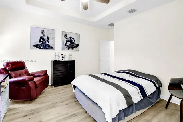 a bedroom with bed and wooden floor