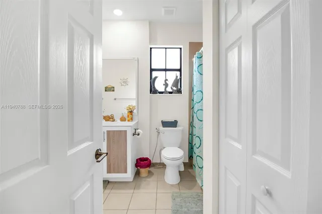 a bathroom with a toilet and shower curtain