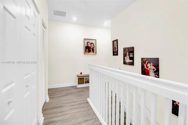 a view of a hallway with a white walls and a white refrigerator