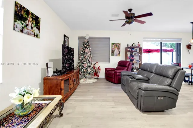 a living room with furniture flowerpot and a chandelier
