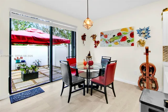 a view of a dining room with furniture a chandelier and a window
