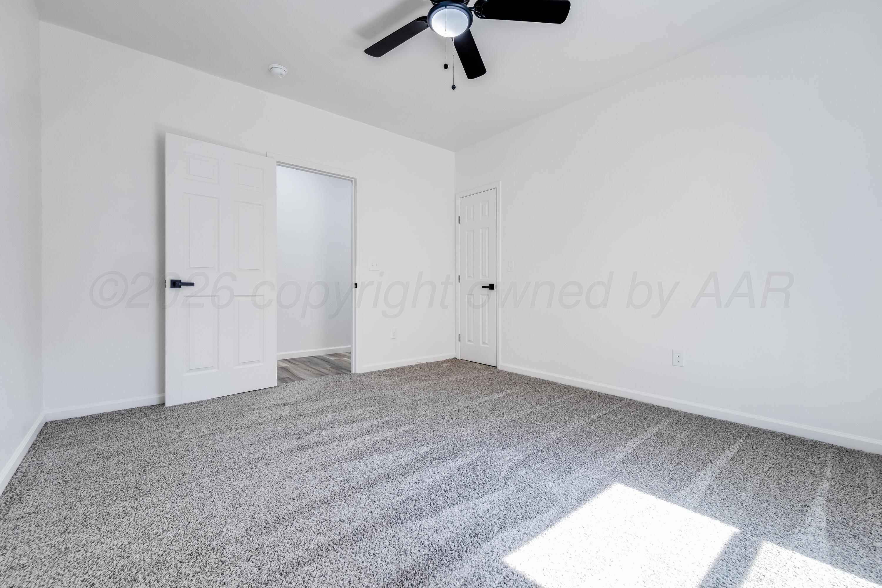 409 South Forest Street Amarillo, TX 79106 - Photo 9 of 18 an empty room with a ceiling fan and carpet