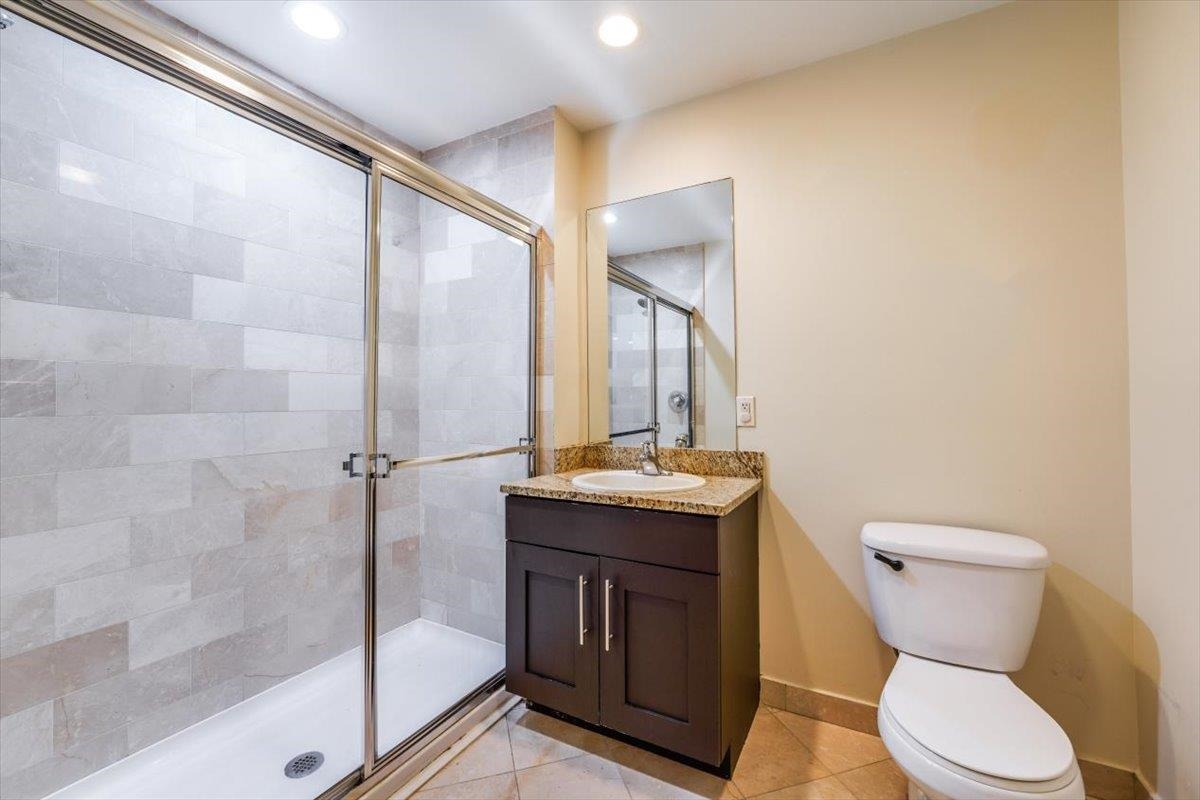 29 1st Street, Unit 408 Hackensack, NJ 07601 - Photo 20 of 29 a bathroom with a granite countertop toilet sink and mirror