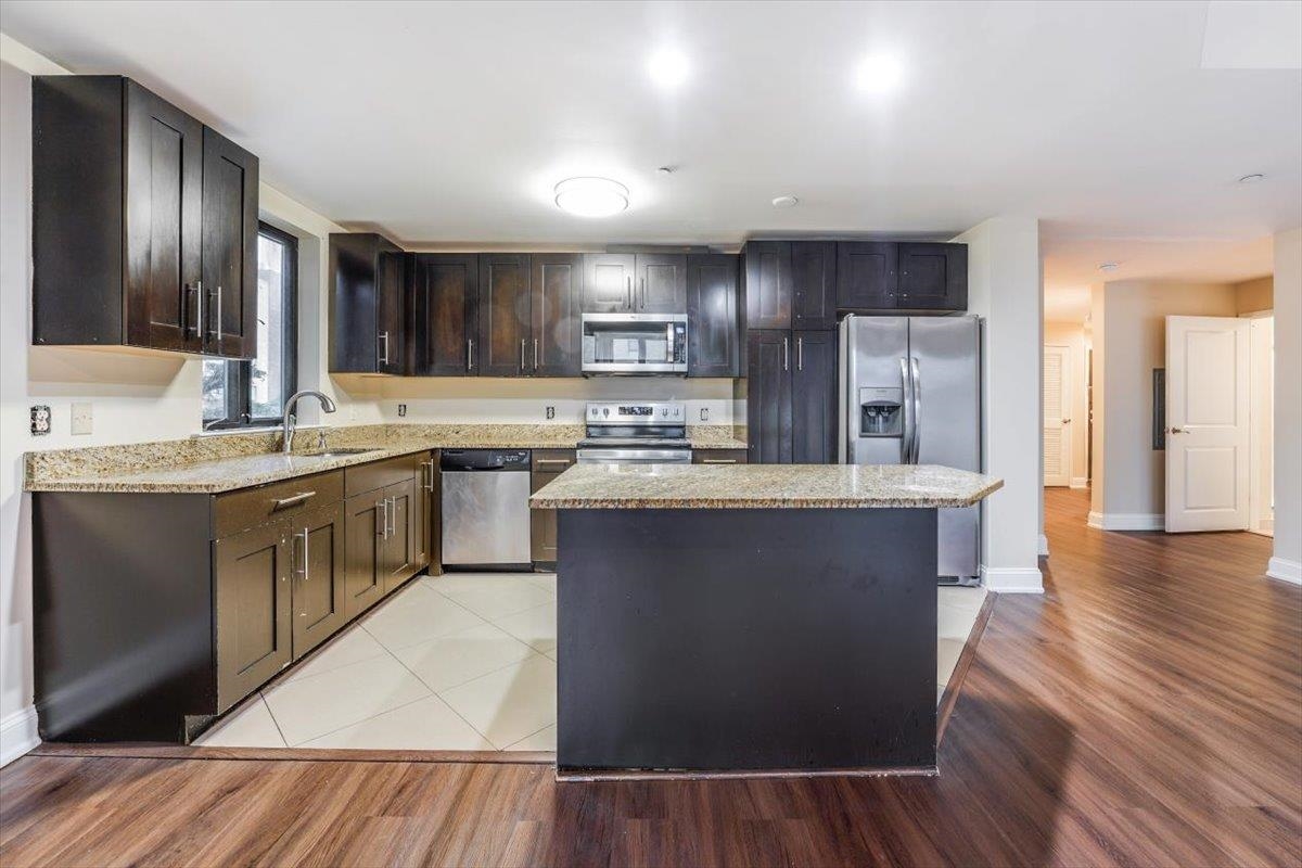 29 1st Street, Unit 408 Hackensack, NJ 07601 - Photo 3 of 29 a kitchen with stainless steel appliances granite countertop a sink a stove and a refrigerator