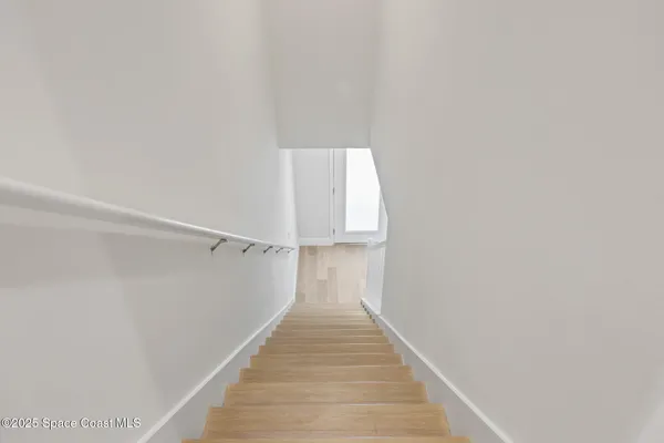 a view of a hallway with wooden floor and entryway