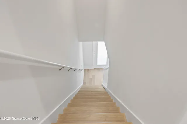 a view of a hallway with wooden floor and entryway