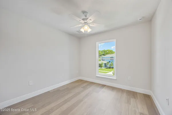 an empty room with window and wooden floor