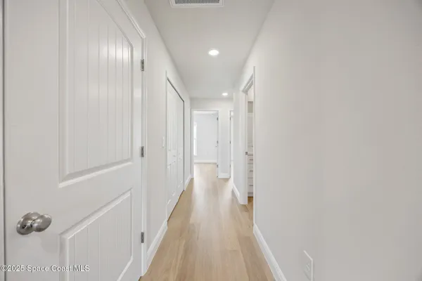 a view of a hallway with wooden floor