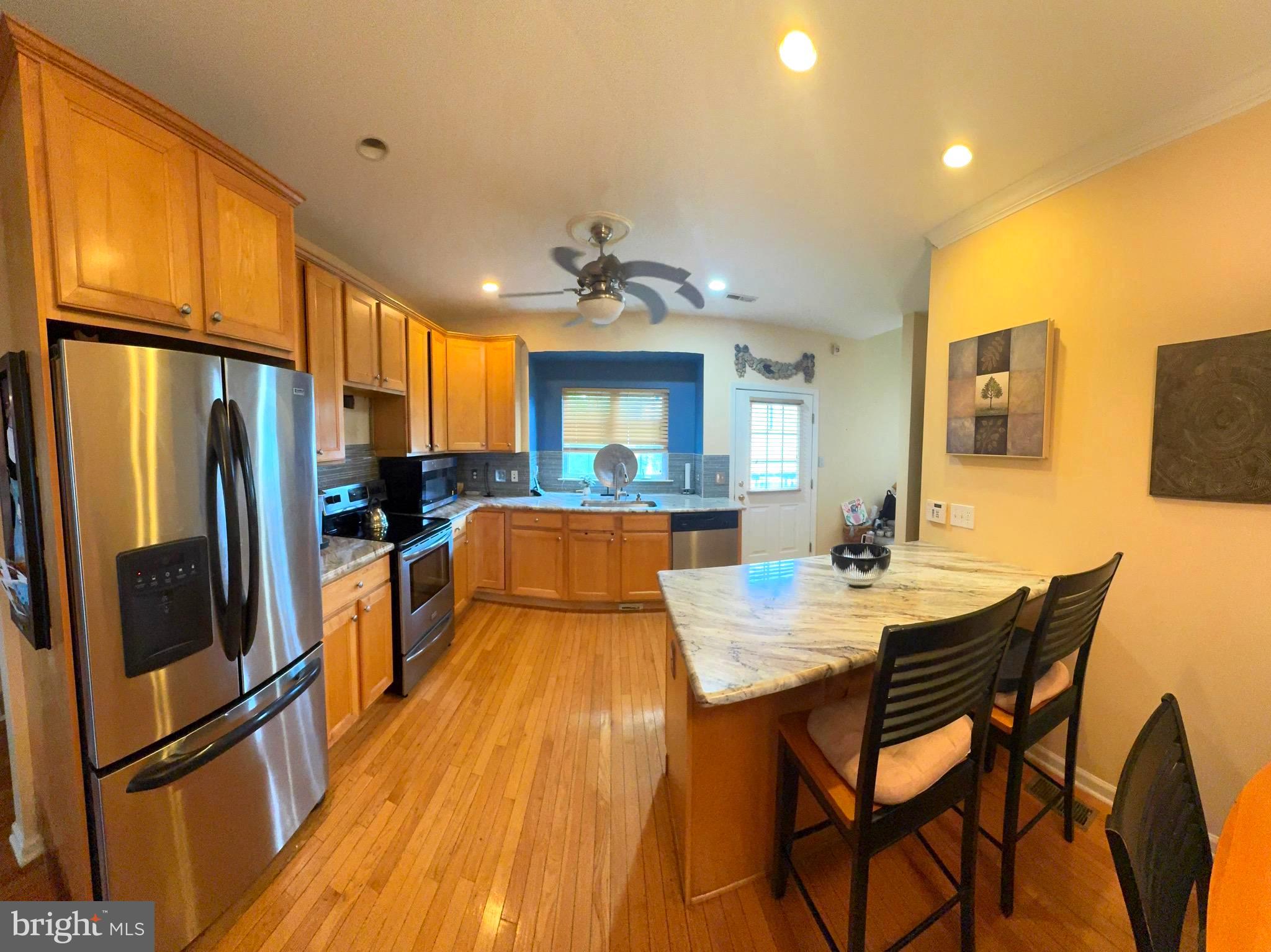 20 Wilson Way Delanco, NJ 08075 - Photo 9 of 38 a large kitchen with stainless steel appliances granite countertop a refrigerator a oven a sink a dining table and chairs with wooden floor