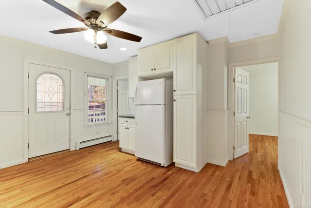 a view of a big room with wooden floor and a ceiling fan