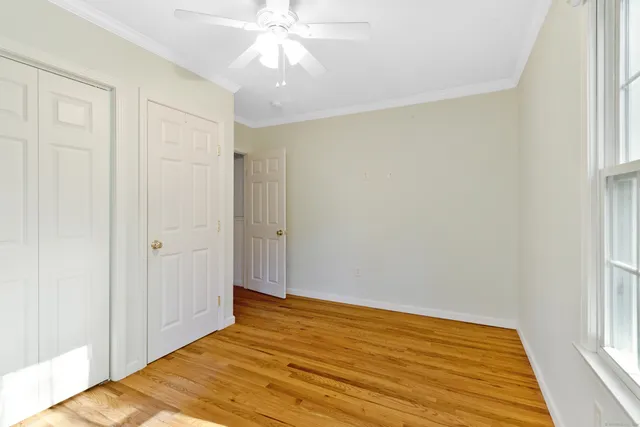 a view of a room with wooden floor and fan