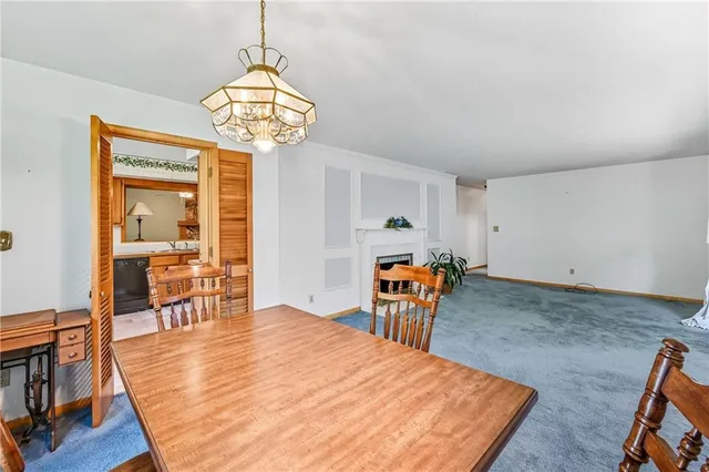 a dining room with wooden floor a chandelier a wooden table and chairs