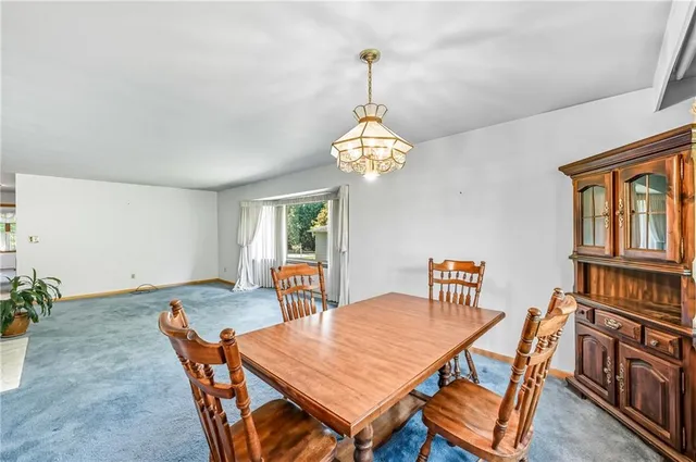 a dining room with furniture a chandelier and window