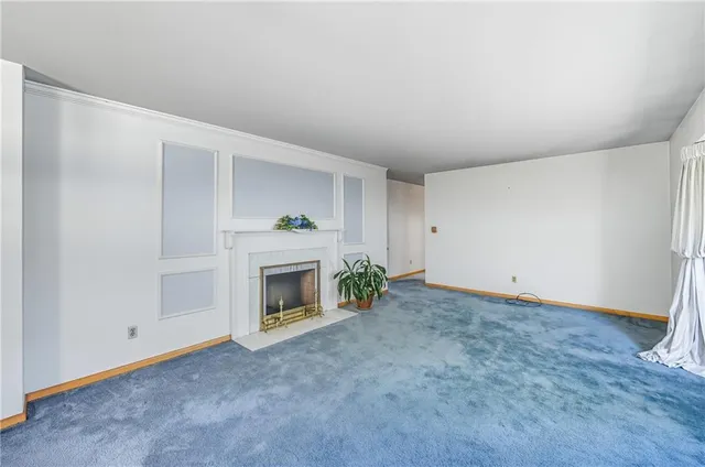 a view of empty room with window and fireplace