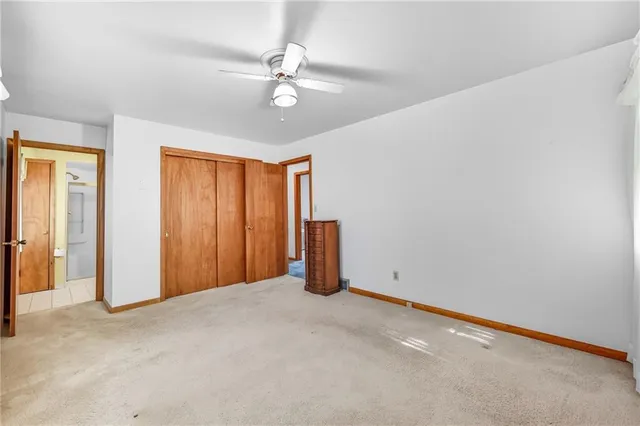 a view of an empty room with a chandelier fan