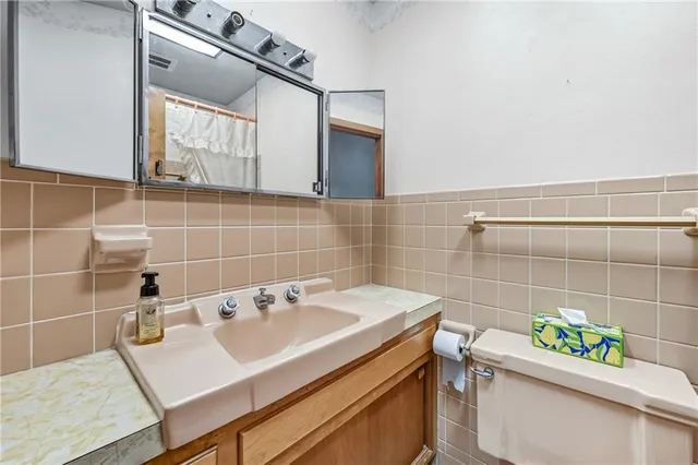 a bathroom with a sink toilet and a mirror