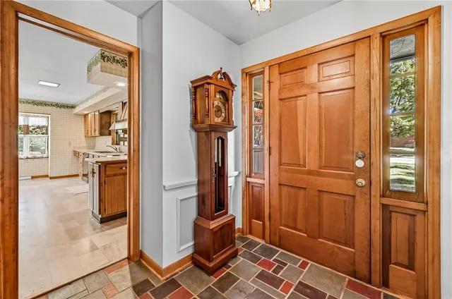 a view of a hallway with stainless steel appliances granite countertop cabinets and a window