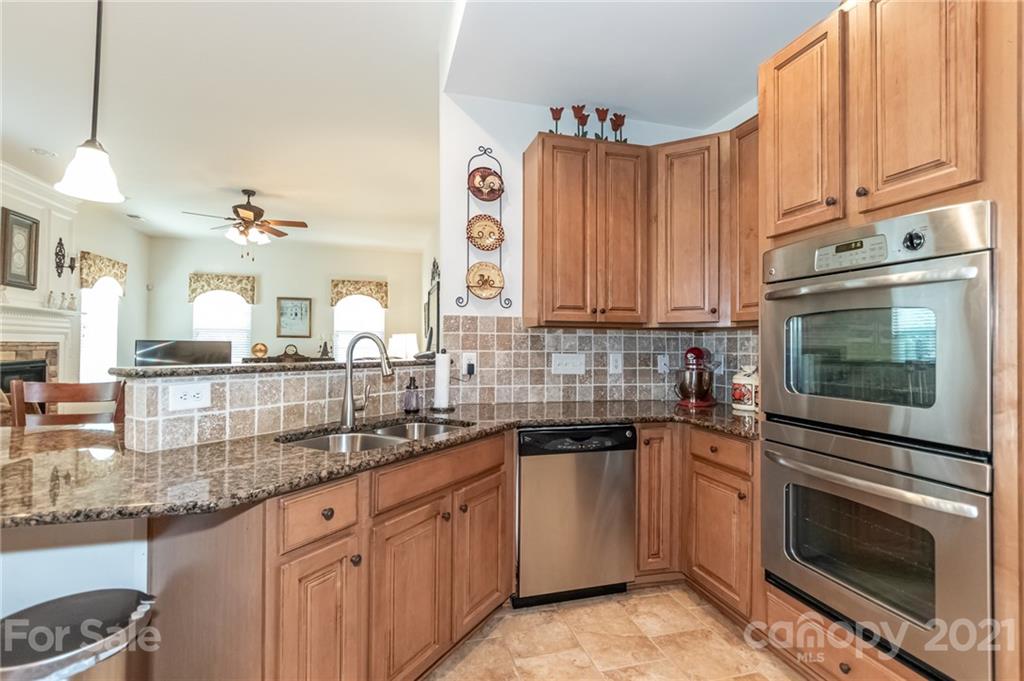 7116 Meyer Road Fort Mill, SC 29715 - Photo 18 of 31 a kitchen with stainless steel appliances granite countertop a sink a stove and cabinets
