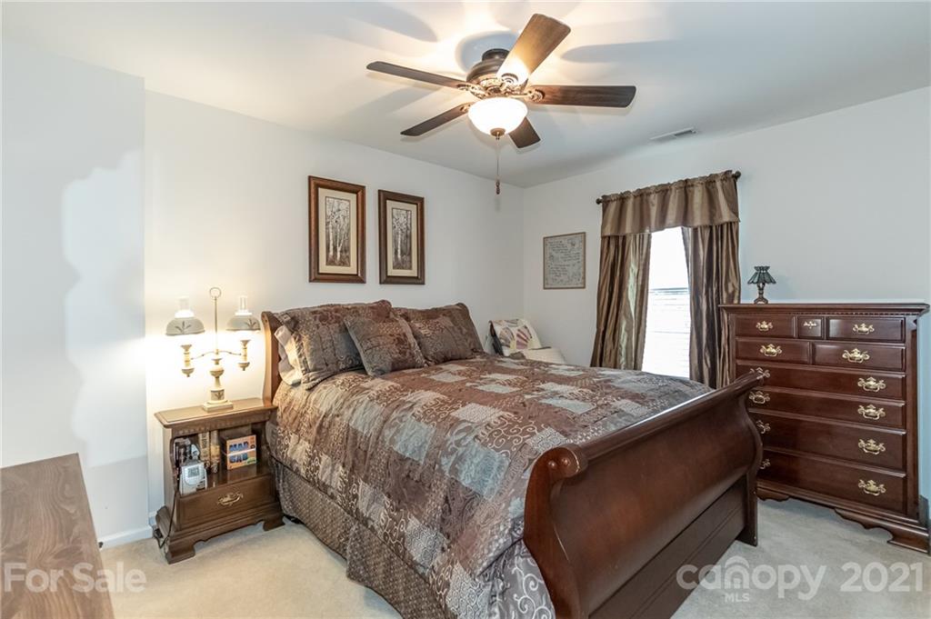 7116 Meyer Road Fort Mill, SC 29715 - Photo 26 of 31 a bedroom with a bed and a chandelier