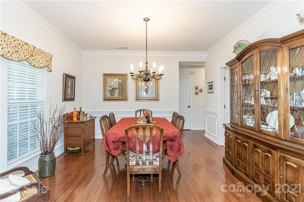 7116 Meyer Road Fort Mill, SC 29715 - Photo 6 of 31 a dining room with furniture a chandelier and wooden floor