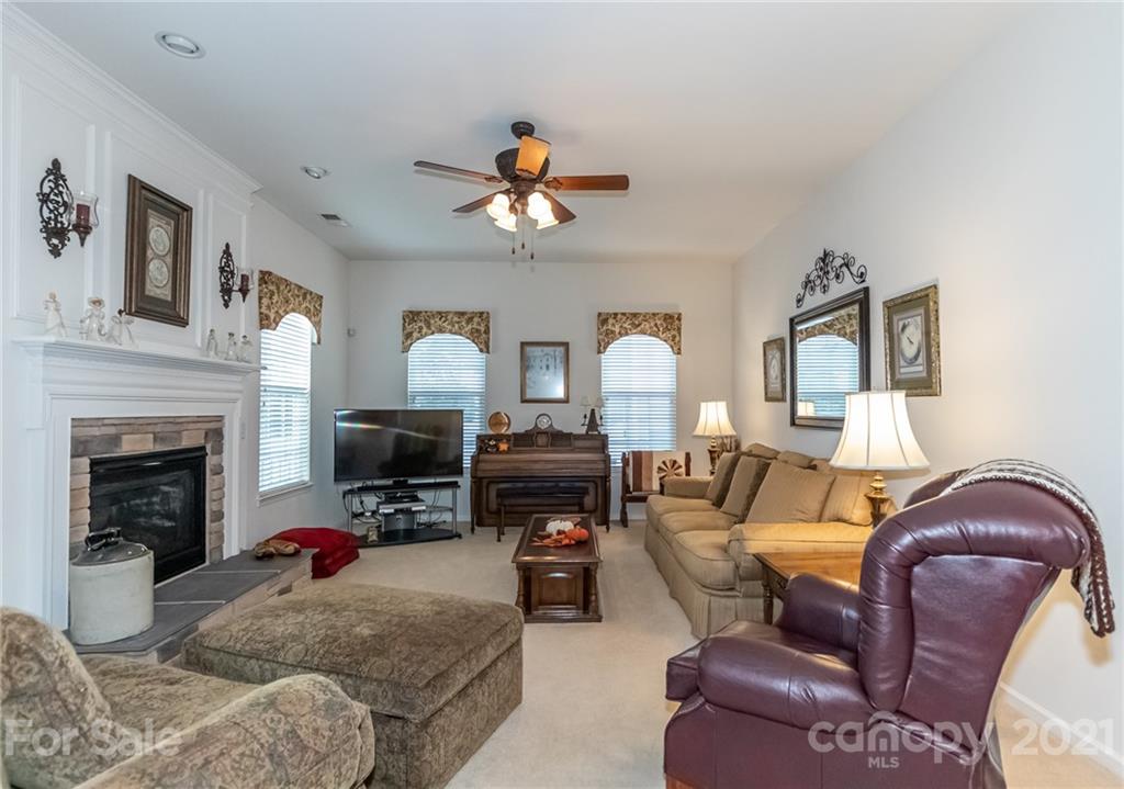 7116 Meyer Road Fort Mill, SC 29715 - Photo 8 of 31 a living room with furniture a fireplace and a chandelier