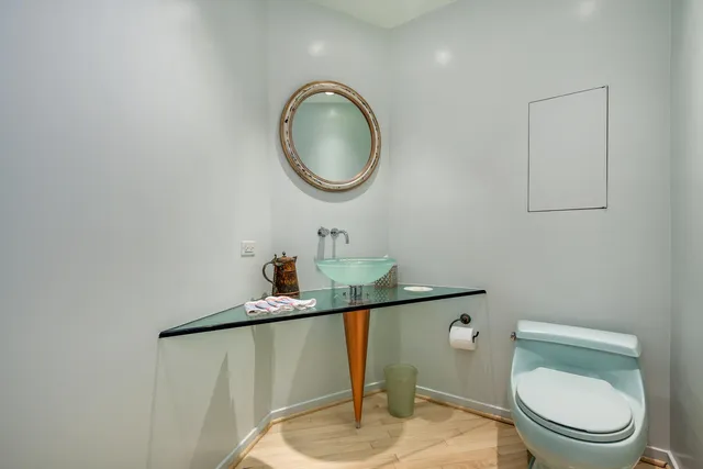 a bathroom with a toilet a sink and a mirror