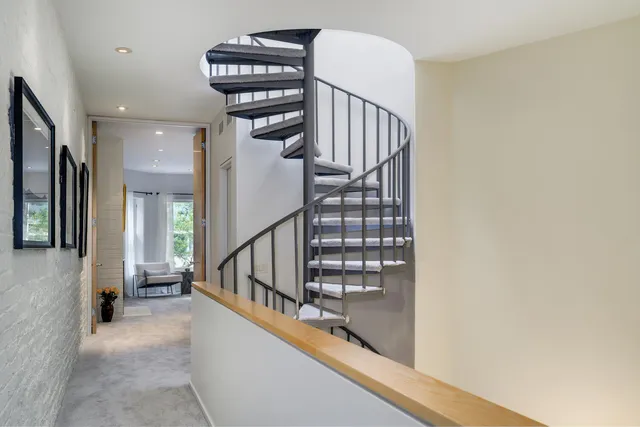 a view of staircase with lots of frames on wall and a window